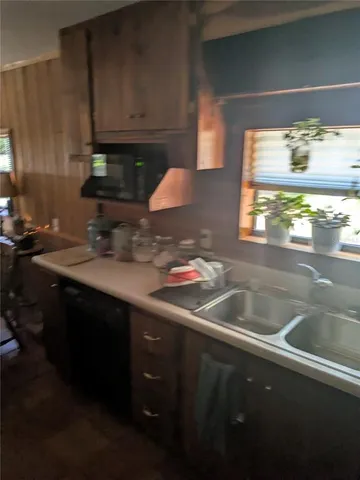 a kitchen with stainless steel appliances a stove a sink dishwasher and cabinets with wooden floor