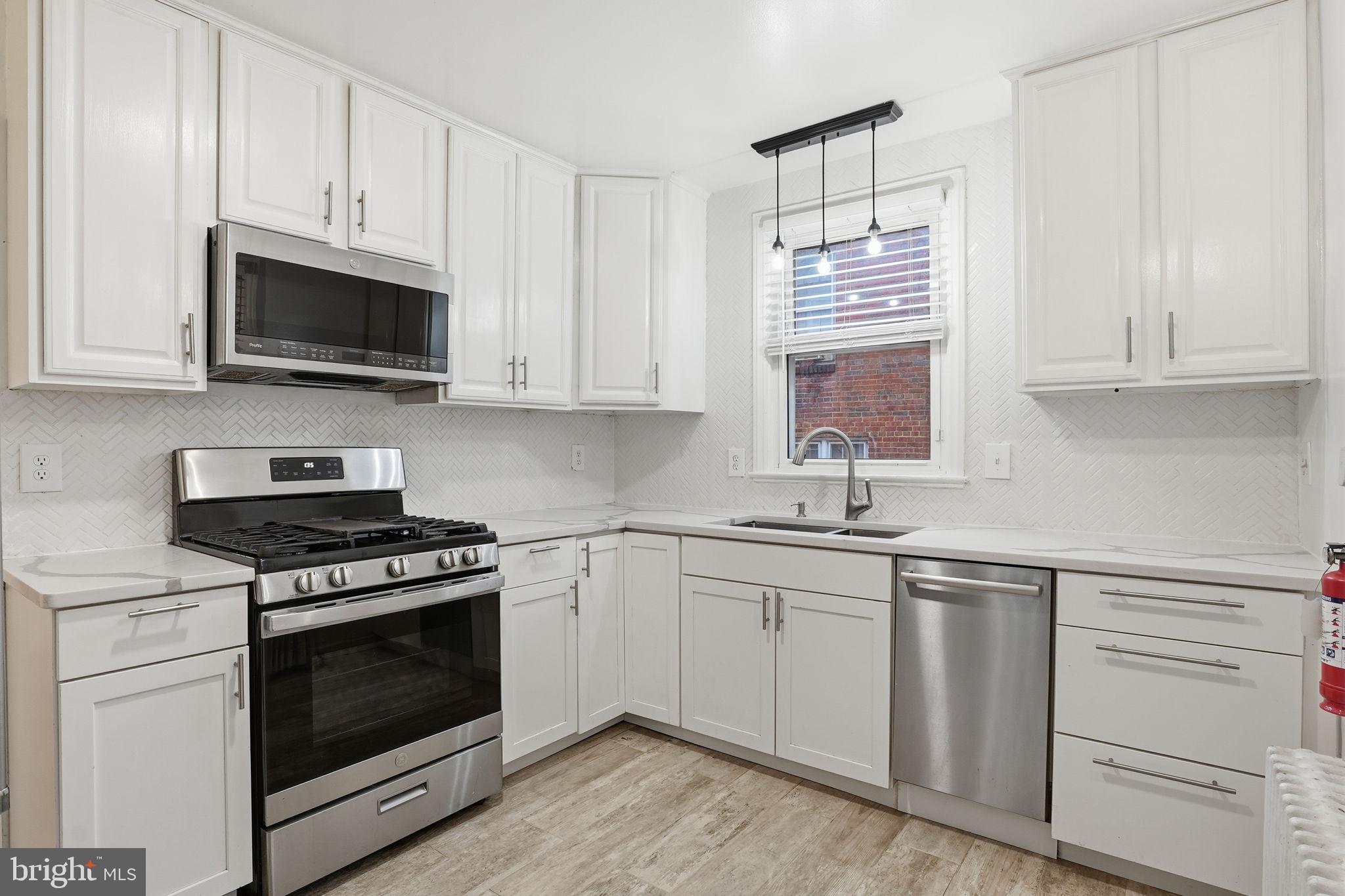 a kitchen with cabinets appliances a sink and a window