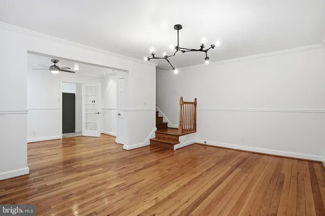 a view of empty room with wooden floor and window