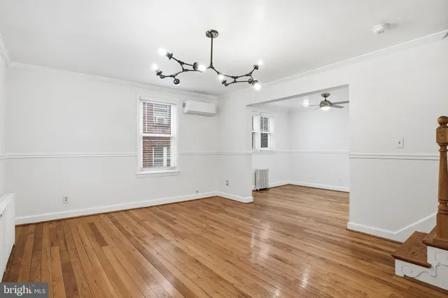 a view of empty room with wooden floor and ceiling fan