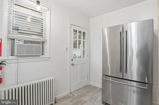 a view of kitchen with stainless steel appliances wooden floor and window