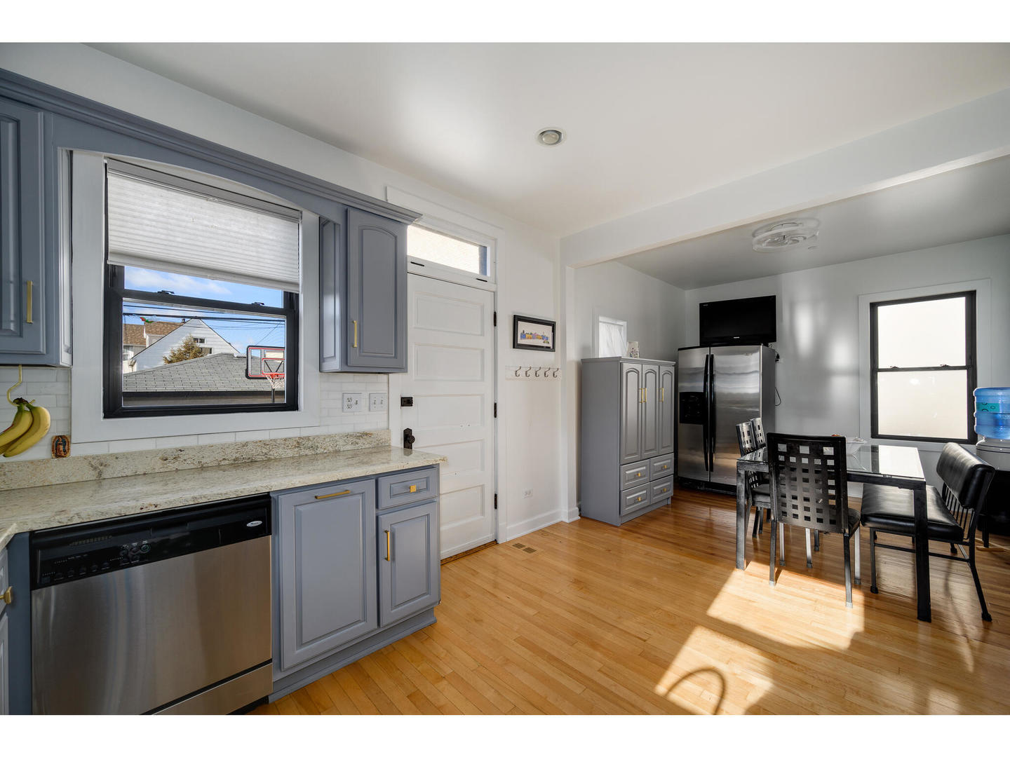 4500 North Harding Avenue Chicago, IL 60625 - Photo 10 of 29 a kitchen with stainless steel appliances granite countertop a refrigerator a stove a dining table and chairs with wooden floor