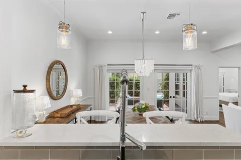 a living room with furniture a large window and a chandelier