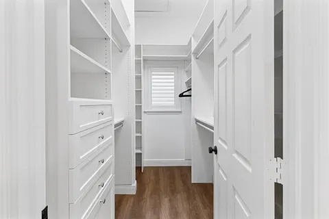 a view of walk in closet with wooden floor