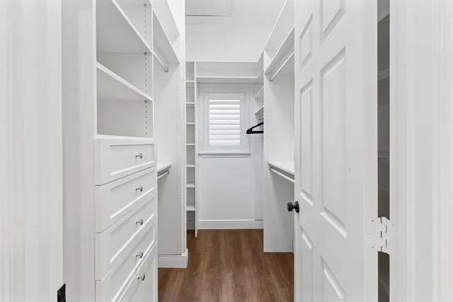 a view of walk in closet with wooden floor