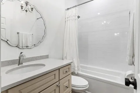 a bathroom with a sink a toilet and a mirror