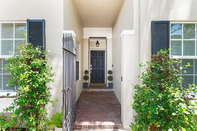 a view of a pathway along a house with potted plants