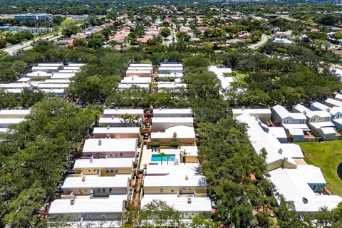 an aerial view of residential house with outdoor space and trees all around