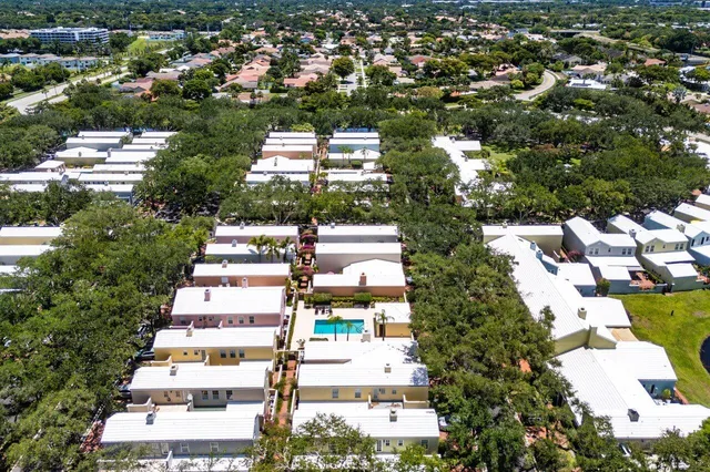 an aerial view of residential house with outdoor space and trees all around