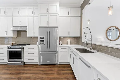 a kitchen with white cabinets and stainless steel appliances