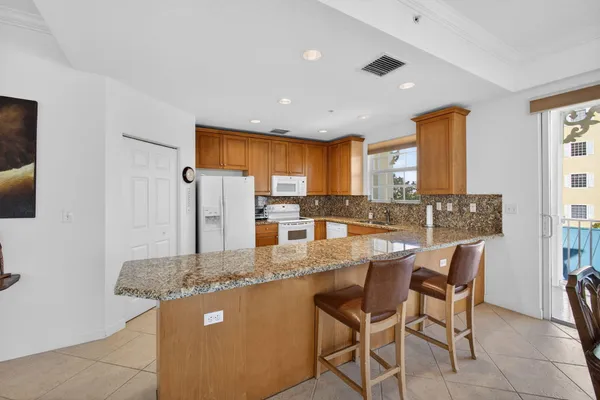 a kitchen with granite countertop a sink and dishwasher with wooden floor