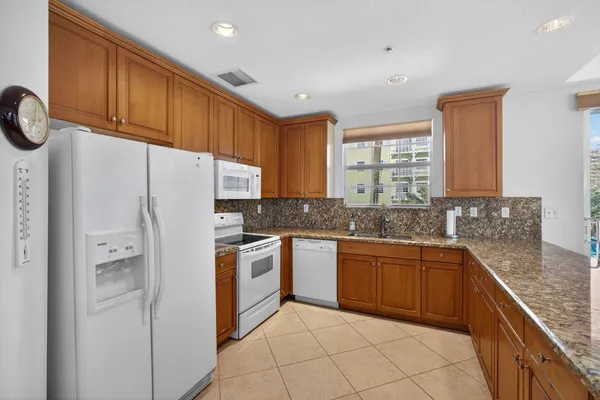 a kitchen with a refrigerator and a stove top oven