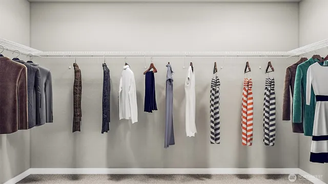 a view of walk in closet with clothes and shoes