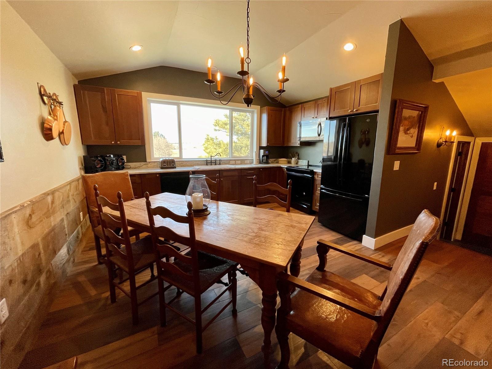 26794 Maul Road Elbert, CO 80106 - Photo 16 of 44 a view of a dining room with furniture window and wooden floor