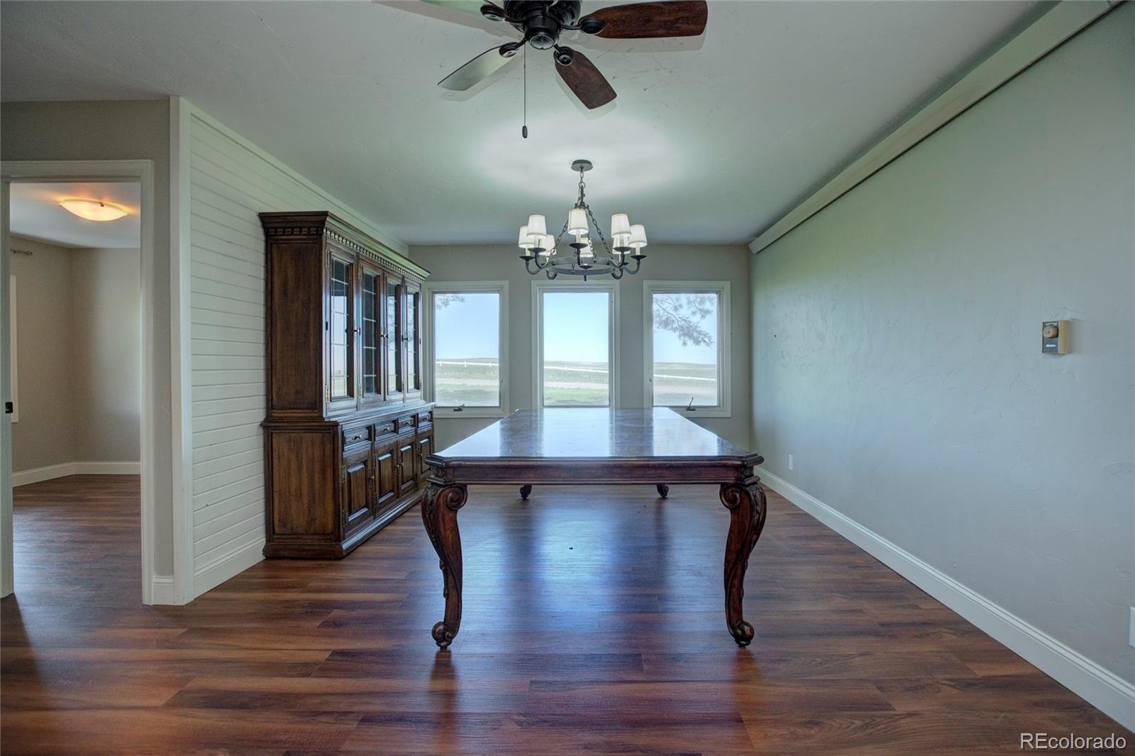 26794 Maul Road Elbert, CO 80106 - Photo 25 of 44 a view of a room with wooden floor chandelier and windows
