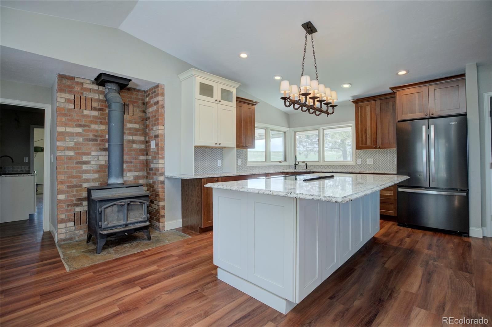 26794 Maul Road Elbert, CO 80106 - Photo 26 of 44 a kitchen with kitchen island granite countertop a stove refrigerator and oven