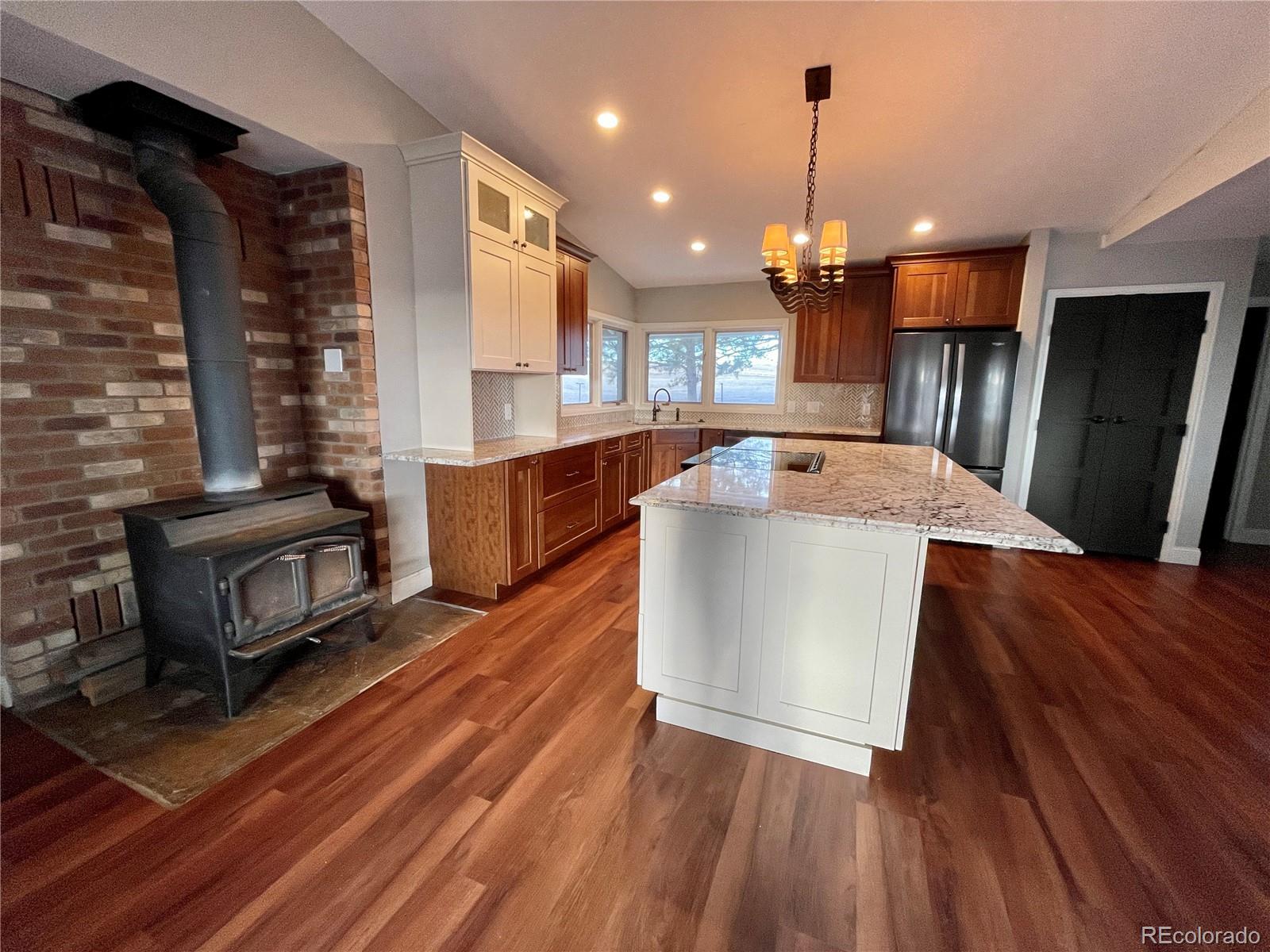 26794 Maul Road Elbert, CO 80106 - Photo 7 of 44 a kitchen with stainless steel appliances granite countertop a sink a stove and a wooden floors