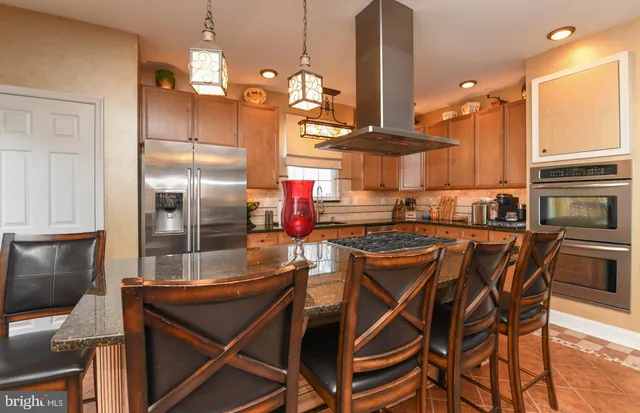 a kitchen with stainless steel appliances granite countertop a stove top oven a sink dishwasher and cabinets with wooden floor