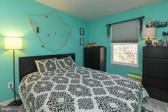 a spacious bedroom with a bed and a lamp