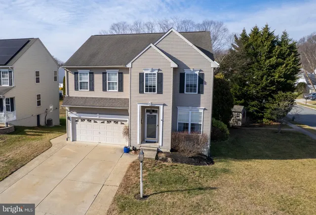 a view of a white house with large windows next to a yard