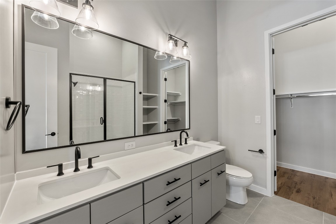 4510 Terry-O Lane, Unit 141 Austin, TX 78745 - Photo 10 of 29 Bathroom featuring a shower stall, double vanity, a sink, and tile patterned flooring