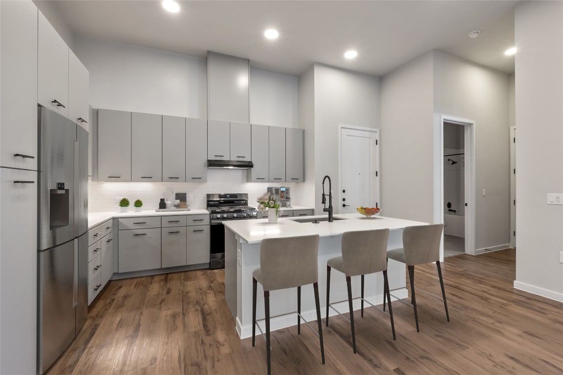 4510 Terry-O Lane, Unit 141 Austin, TX 78745 - Photo 3 of 29 Kitchen with a sink, under cabinet range hood, a high ceiling, and stainless steel appliances