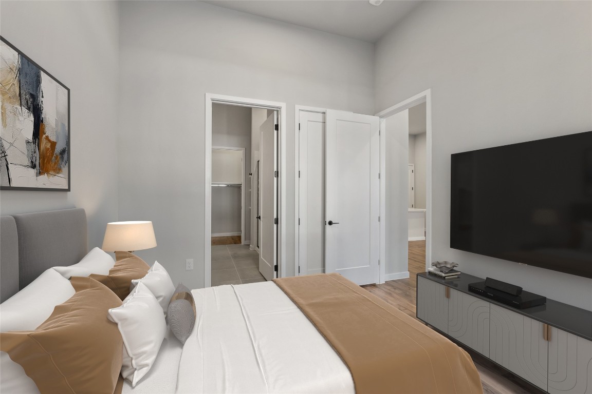 4510 Terry-O Lane, Unit 141 Austin, TX 78745 - Photo 9 of 29 Bedroom with ensuite bath, light wood-style flooring, and baseboards