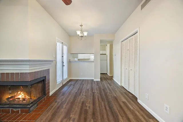 a view of kitchen and empty room with wooden floor