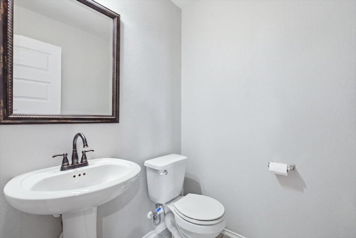 104 Rooster Way Jarrell, TX 76537 - Photo 24 of 33 A classic pedestal sink paired with neutral walls completes this functional half bath.
