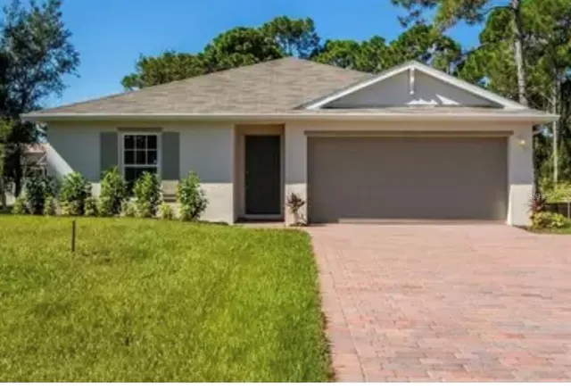 a front view of a house with a yard and potted plants