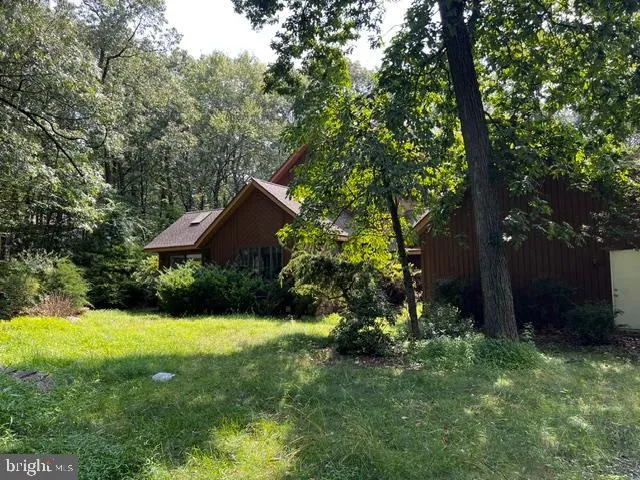 a view of a house with a yard and tree s