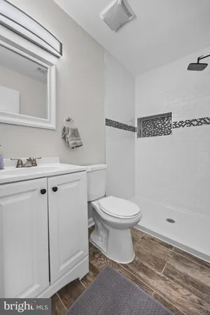 a bathroom with a shower a mirror and a sink
