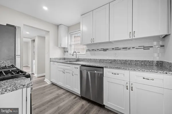 a kitchen with stainless steel appliances granite countertop a stove and a sink