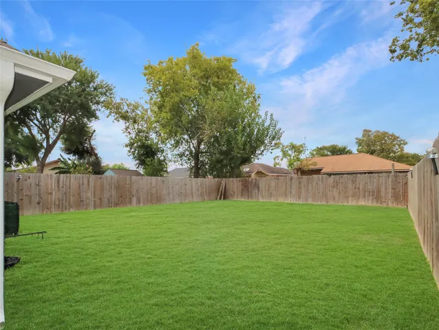 a view of backyard with a wooden fence