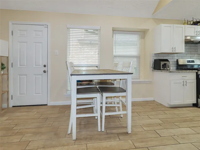 a kitchen with stainless steel appliances a stove a sink cabinets and a window