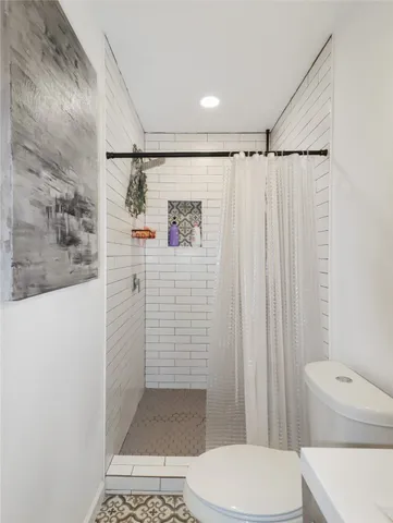 a bathroom with a shower a toilet and sink