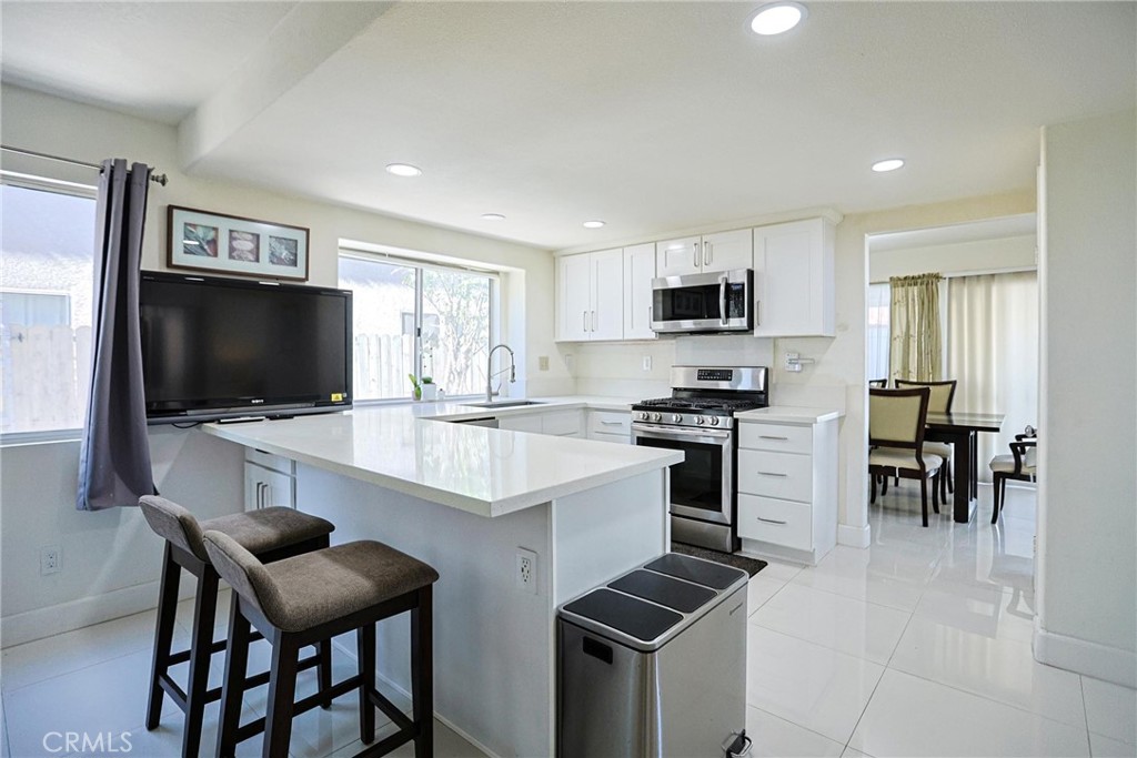 13079 Winterpark Way Riverside, CA 92503 - Photo 12 of 33 a kitchen with stainless steel appliances kitchen island granite countertop a sink and cabinets