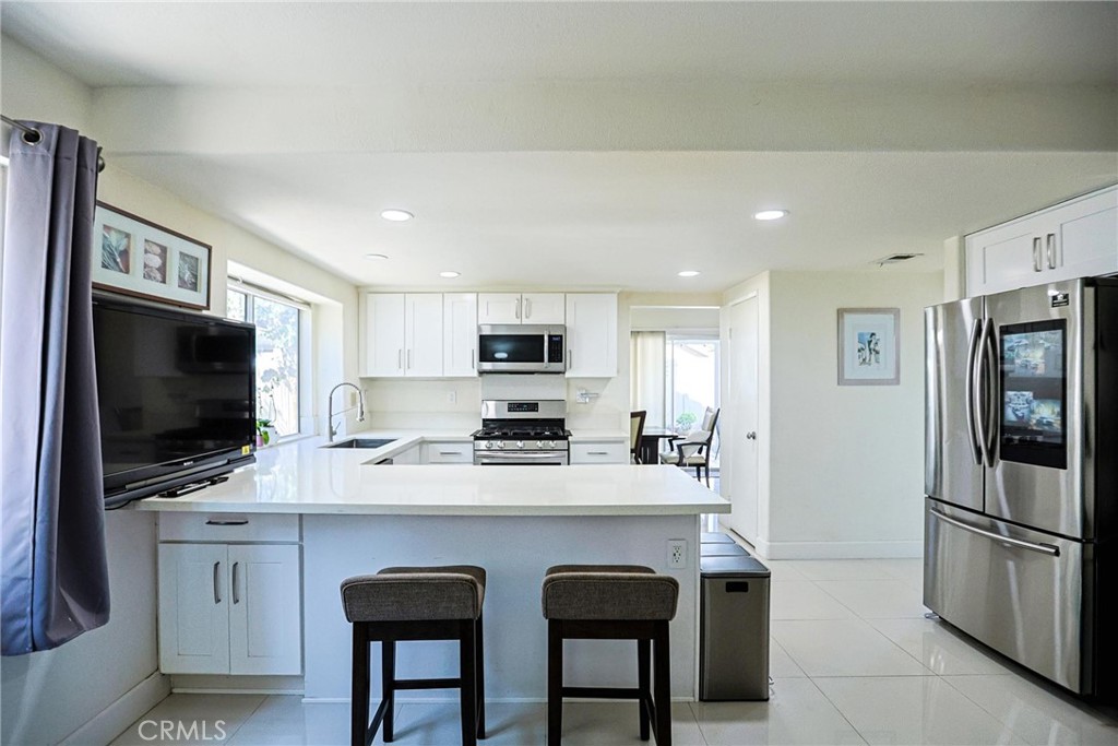 13079 Winterpark Way Riverside, CA 92503 - Photo 13 of 33 a kitchen with stainless steel appliances a stove refrigerator sink and microwave