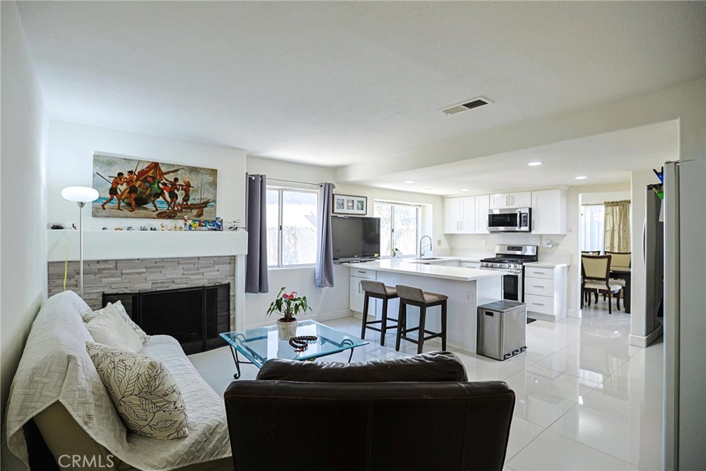 13079 Winterpark Way Riverside, CA 92503 - Photo 15 of 33 a living room with furniture a fireplace and kitchen view