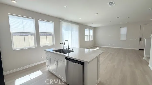 a kitchen with a sink a window and wooden floor