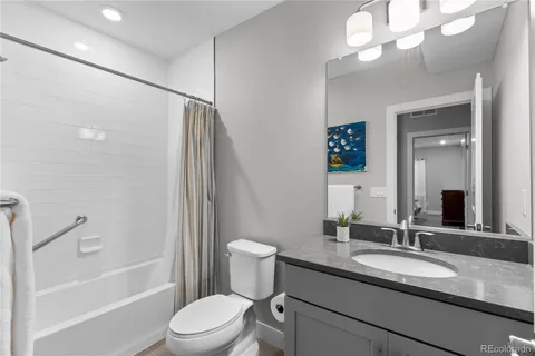 a bathroom with a granite countertop sink toilet and shower