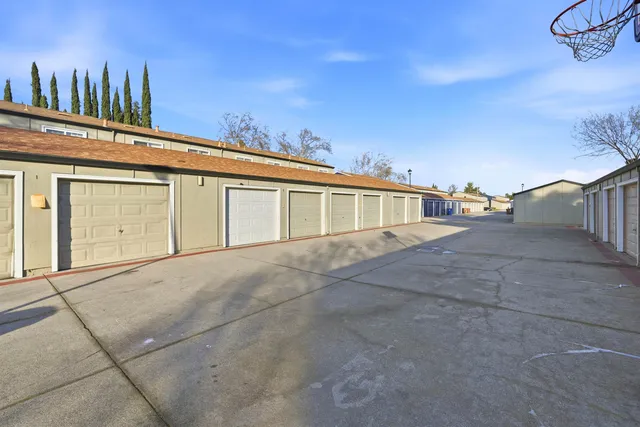 a view of a brick house with many windows next to a yard