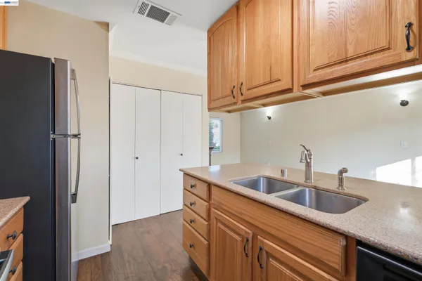a kitchen with stainless steel appliances granite countertop a sink and a refrigerator