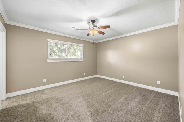 an empty room with windows and ceiling fan