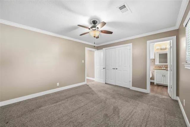 an empty room with closet and a ceiling fan