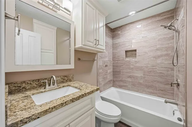 a bathroom with a granite countertop sink toilet and shower