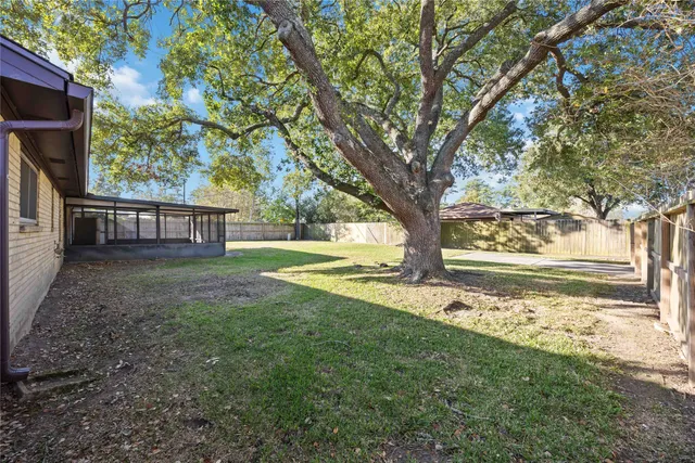 a view of a house with backyard and tree