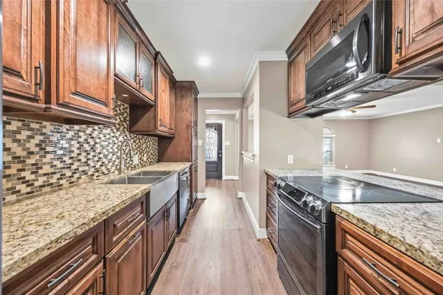 a kitchen with stainless steel appliances granite countertop a kitchen stove a sink dishwasher and cabinets with wooden floor