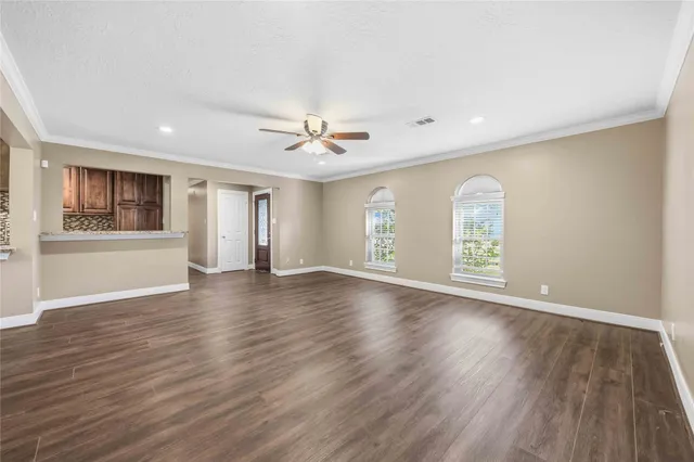 a view of an empty room with a window and wooden floor