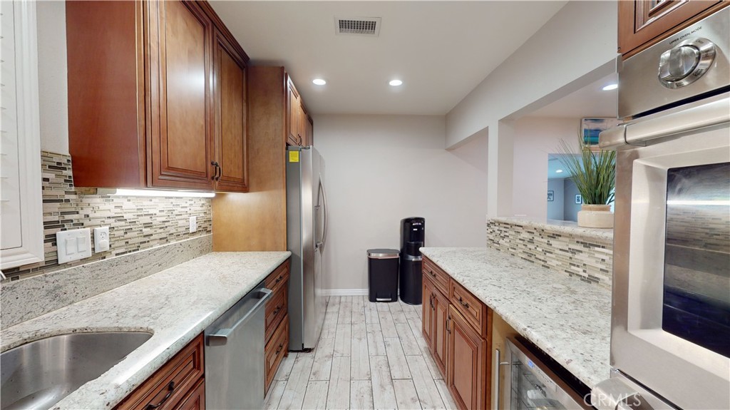 10039 Primrose Drive Riverside, CA 92503 - Photo 12 of 56 a kitchen with stainless steel appliances granite countertop a sink stove and refrigerator